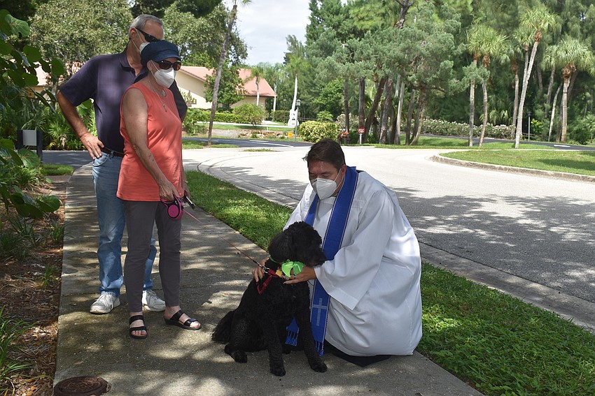 Ed and Ginny Upshaw watch as Father Dave Marshall blesses Reba.