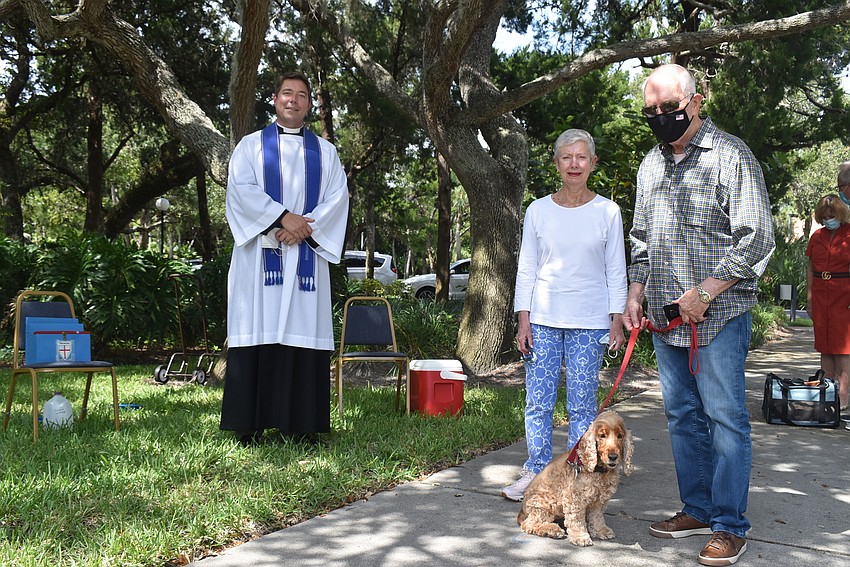 Father Dave Marshall with Gay, Jerry and Maggie Bowles. Maggie is a 14-year-old English cocker spaniel who's been sick, so her humans are trying to help her heal.