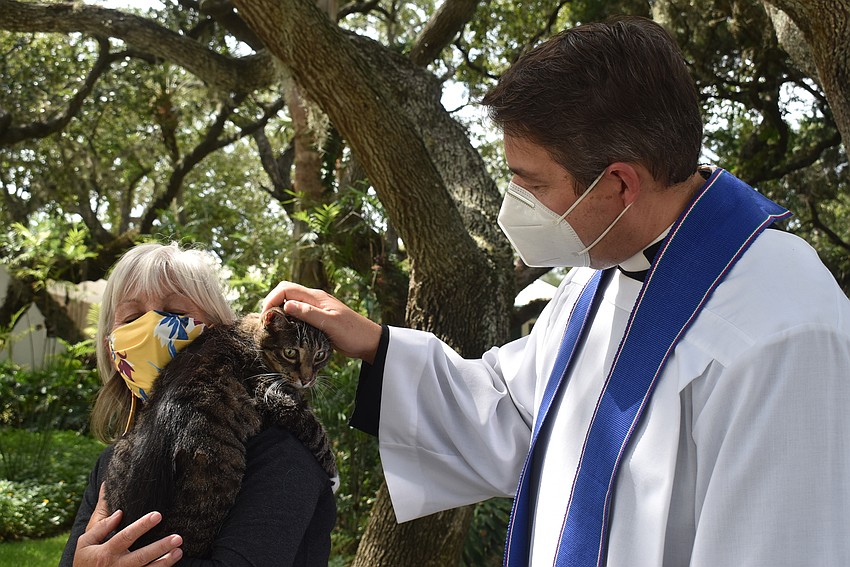 Tamara Wright holds Jessie as Father Dave Marshall introduces himself.