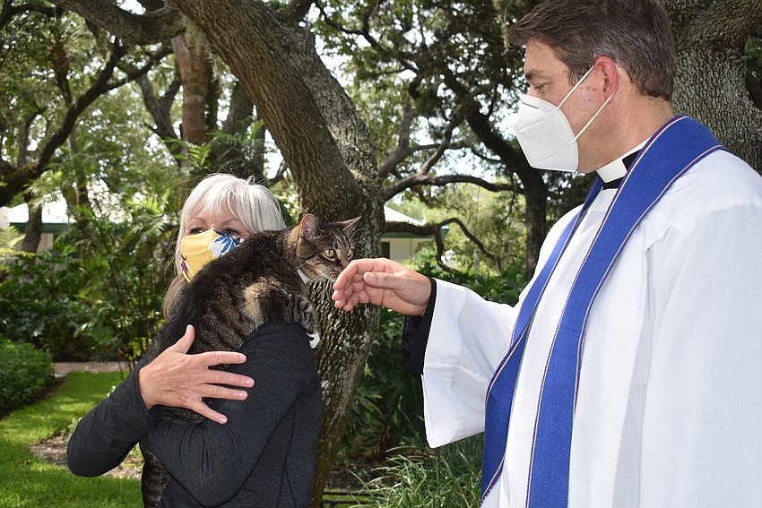 Tamara Wright holds Jessie as Father Dave Marshall introduces himself.