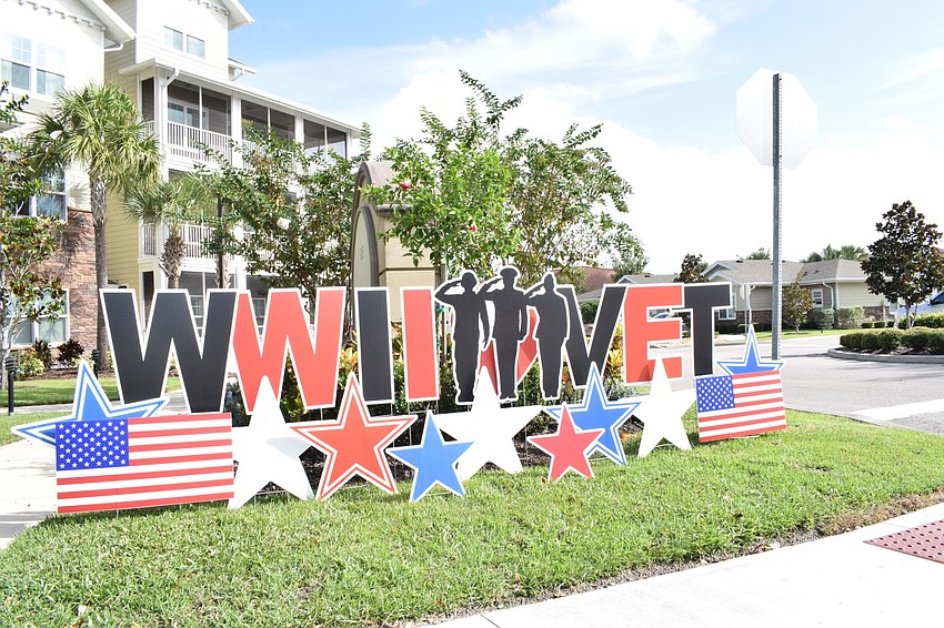 Signs are put up to honor Roger Quisenberry, a World War II veteran, on his 100th birthday.