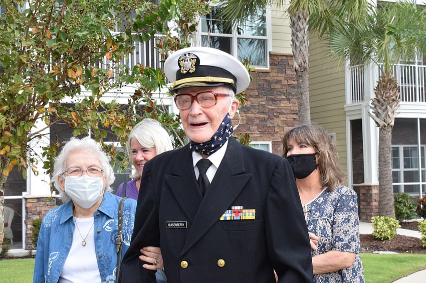 Roger Quisenberry walks with his wife, Margaret Quisenberry, and daughters Jan Wright and Joy Bragg so he can see the parade to celebrate his 100th birthday.
