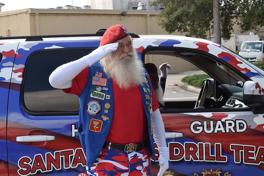 Steve Hadala with the Santa Claus Drill Team salutes Roger Quisenberry, a World War II veteran, celebrating his 100th birthday.