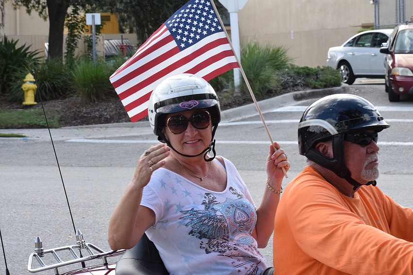 Tonya Ditty, the leading knight of the Lakewood Ranch Elks Lodge, waves while her husband, Jerry Ditty, the exalted ruler of the lodge, drives a motorcycle in the parade.