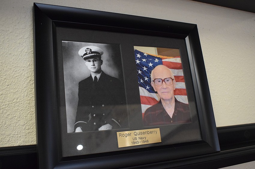 Inside Cypress Springs Gracious Retirement Living hangs a photo of Roger Quisenberry, a resident, from when he served in the Navy and a current photo on the facility's veteran wall.