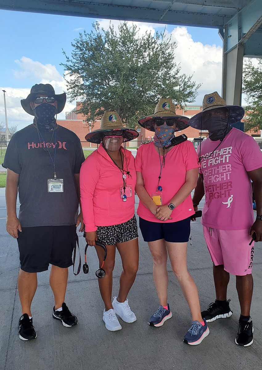 B.D. Gullett Elementary School physical education teachers Brian Walther, Juana Dreier, Amy Wardell and Sean Mackey wear pink to show support for people impacted by breast cancer. Courtesy photo.