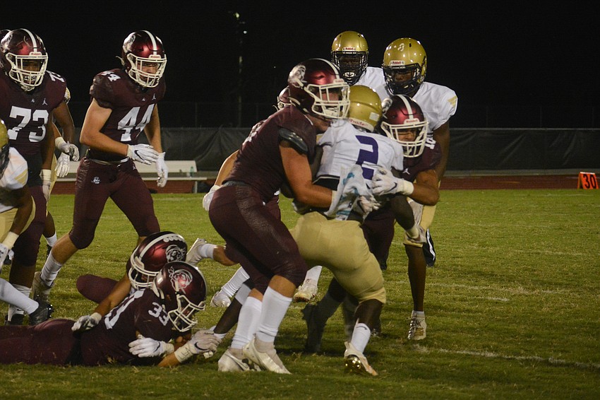 Booker's Dejuan Gordon is stuffed by two Pirates defenders.