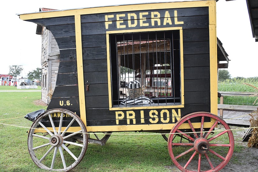 A scarecrow sits in a jail car at the Pumpkin Festival.