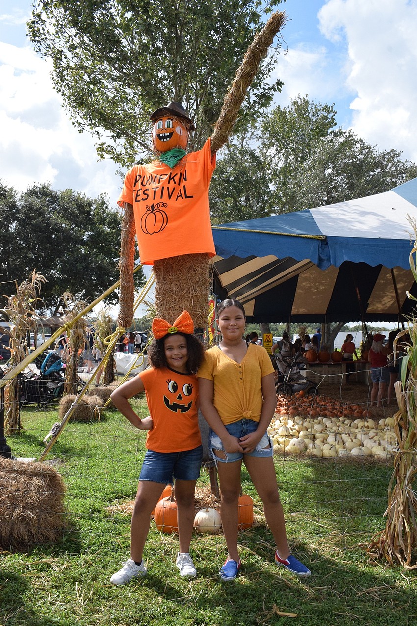 East County's Bella Randall, who is 8, and her sister Chloe Randall, who is 10, start their time at the Pumpkin Festival by observing the scarecrows. The girls look forward to eating ice cream and elephant ears.