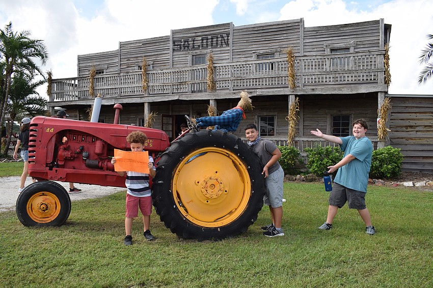 Brandon's Noah Williams, who is 9, Sebastian Garcia, who is 12, and Jakob Scott, who is 12, pose in front of a tractor at the Pumpkin Festival. Garcia looks forward to grabbing kettle corn while at the festival.