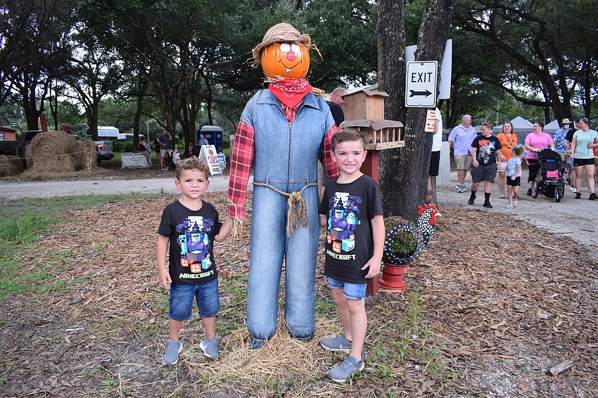 Lakewood Ranch's Nicholas Dadej, who is 3, and his 5-year-old brother Bradley Dadej, commemorate their first Pumpkin Festival with a photo by a scarecrow.