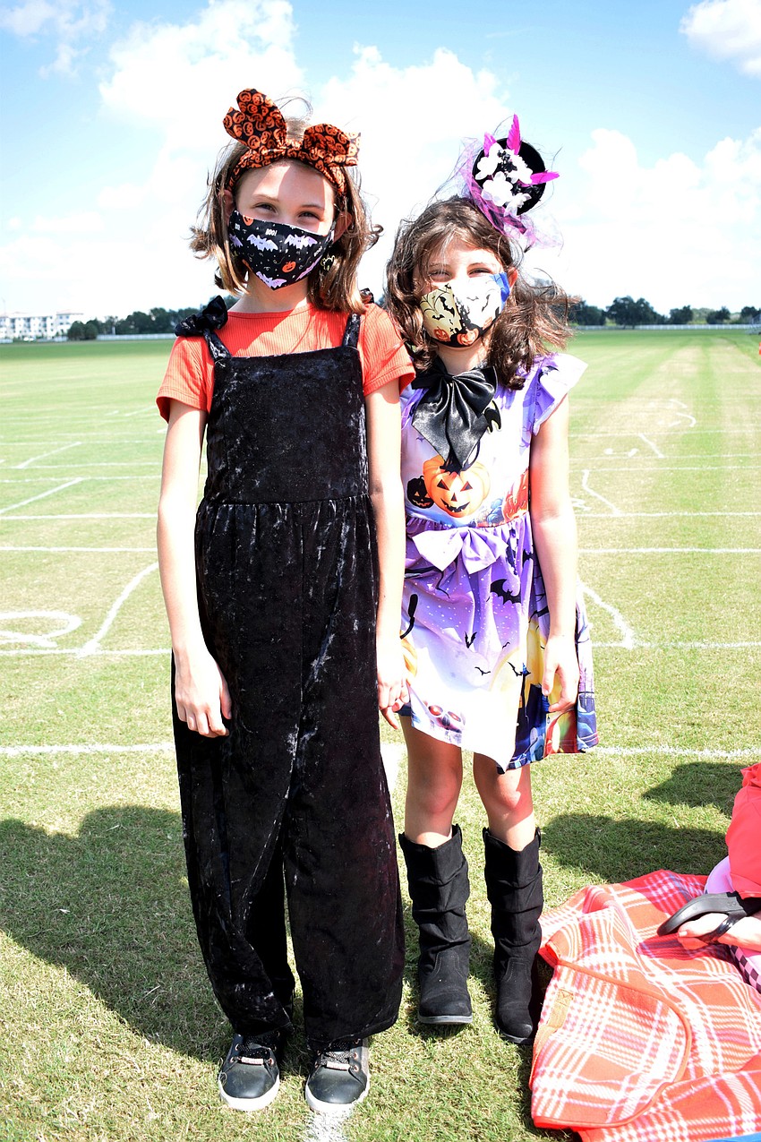 Charlotte Machado, who is 10, and her sister, Elizabeth Machado, who is 7, dress in Halloween costumes for 