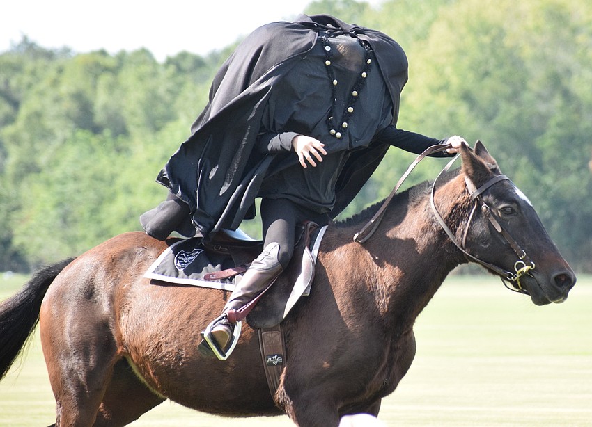 The Headless Horseman (Carmen Hansen) gallops away after dropping a jack-o'-lantern.