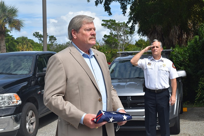 Fire Chief Paul Dezzi (right) saluted retiring Police Chief Pete Cumming on Friday afternoon.