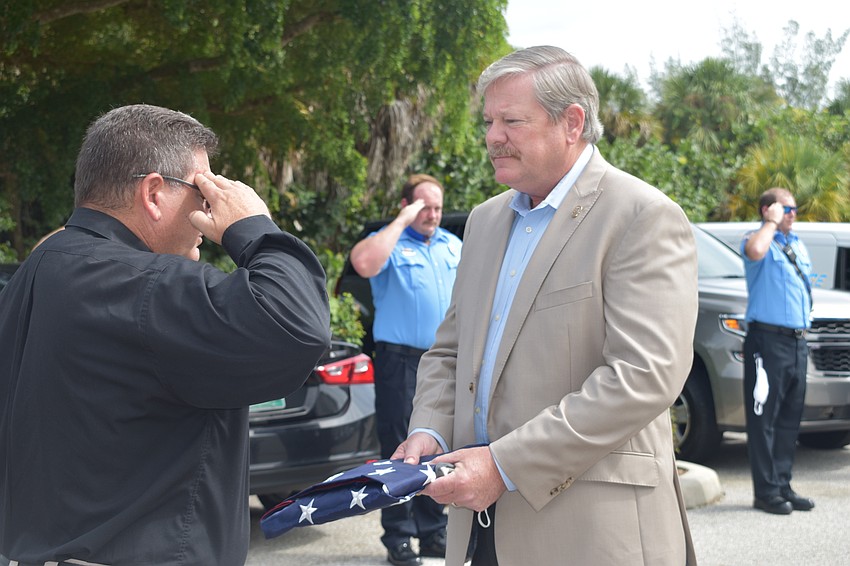Deputy Police Chief Frank Rubino presented retiring Police Chief Pete Cumming with an American flag on Friday afternoon.