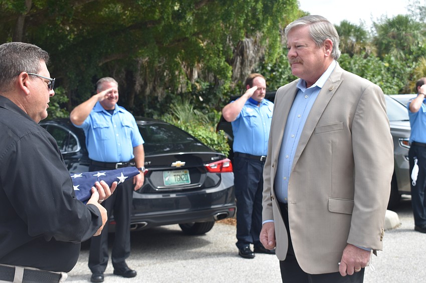 Deputy Police Chief Frank Rubino presented retiring Police Chief Pete Cumming with an American flag on Friday afternoon.