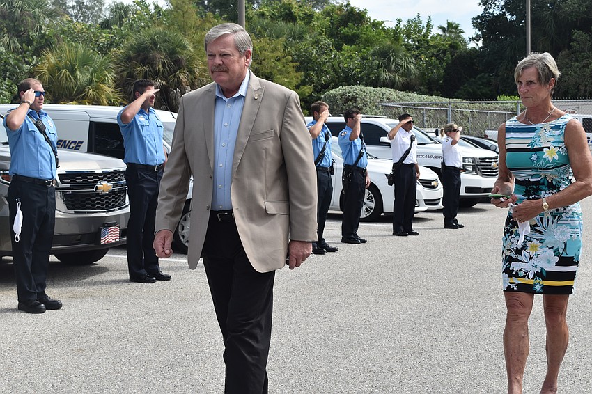 Police officers and firefighters saluted Pete Cumming and his wife Diane as they drove off together in retirement.