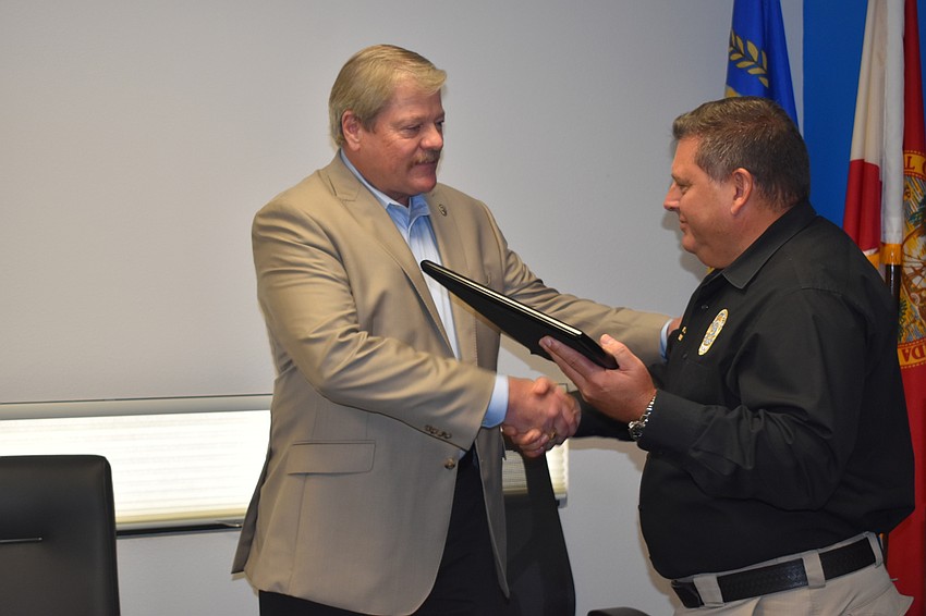 Deputy Police Chief Frank Rubino (left) presented retiring Police Chief Pete Cumming (right) with a commemorative plaque on Friday afternoon.