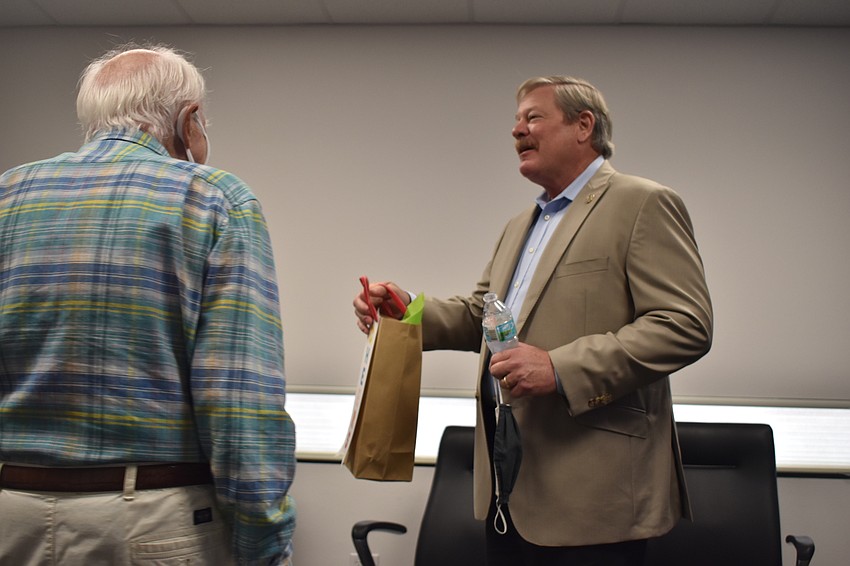 Longboat Key Town Commissioner Ed Zunz (right) presented retiring Police Chief Pete Cumming with a gift on Friday afternoon.