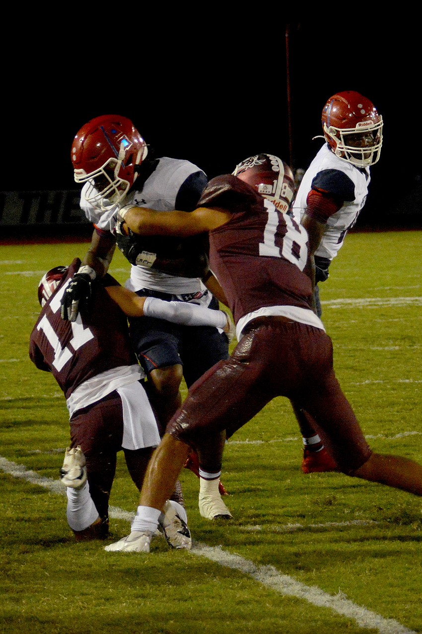 Matt Manning (17) and Isaiah Cress (18) make a tackle along the sideline.