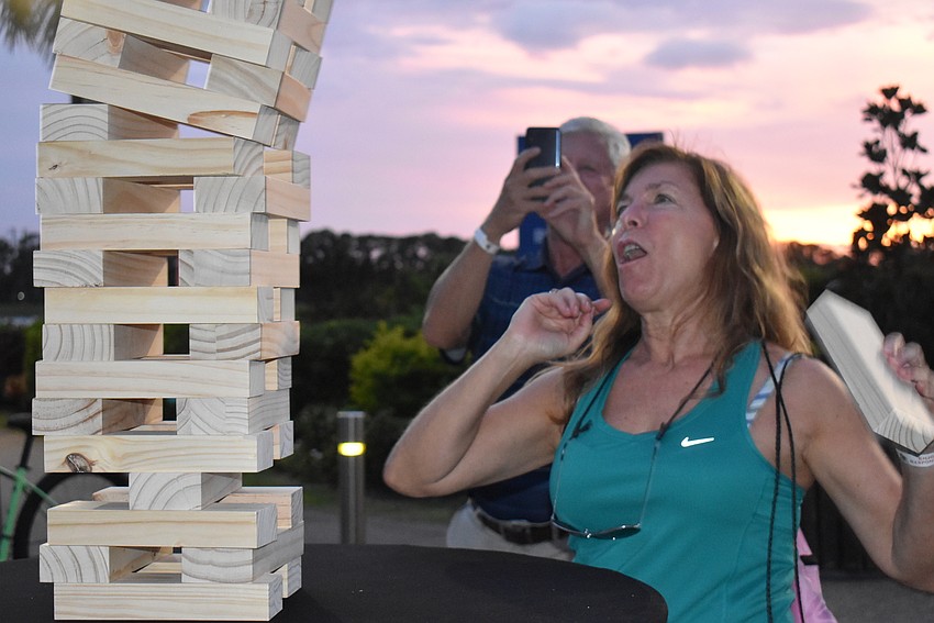 JoAnn Strutt, who works in Lakewood Ranch, watches as the Jenga game she was competing in against Erick Kelton of Sarasota crumbles before her eyes. Strutt said she had a disadvantage because of her short stature.