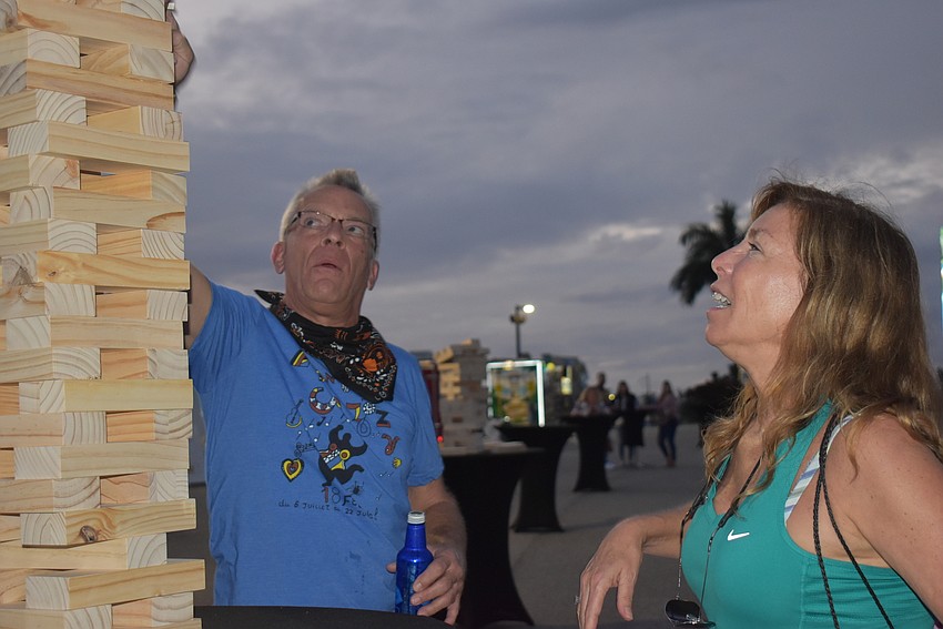Erick Kelton (left) of Sarasota and JoAnn Strutt, who works in Lakewood Ranch, debate the rules of Jenga. Strutt wanted to pull a block off the top of the tower.