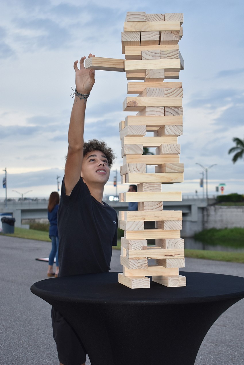 Mark Parsons carefully pulls a block out of the precarious tower deep into a game of Jenga. Parsons lost after a 15- to 20-minute battle with Nala Gato.