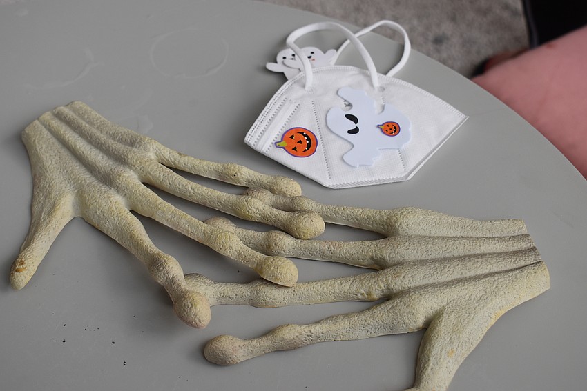 Liz Yerkes left her skeletal hands and homemade spooky mask on the table as she sipped her drink.