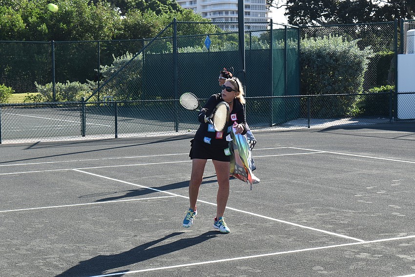 Social butterfly Karen Nuckols returns a practice serve.