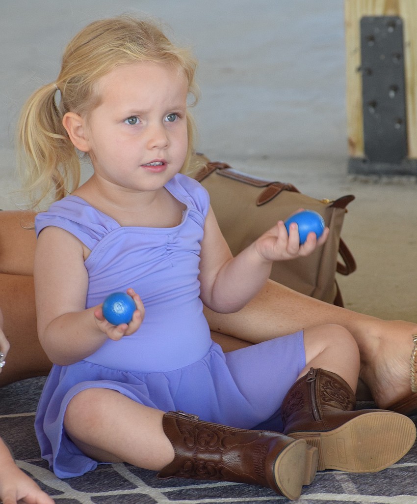 Sarasota's Nora LaDow, who is 2 years old, shakes egg shakers along to the song.