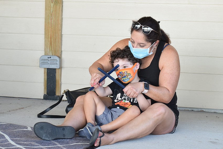 Lakewood Ranch's Randee Bunin and her 3-year-old son Jacob Bunin use sticks to beat along to 