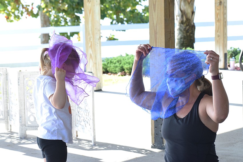 River Walk's Avery Zych, who is 2 years old, and her mother, Jennifer Zych, cover their faces with their scarves.