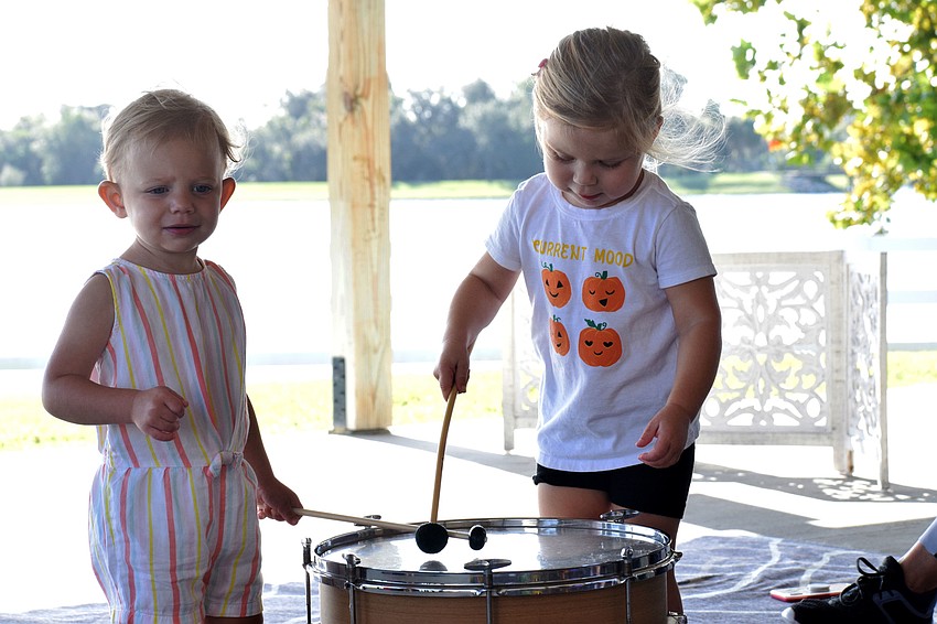 Harmony's Josie McComas, who is 1, and River Walk's Avery Zych, who is 2, play on a drum together during free play.