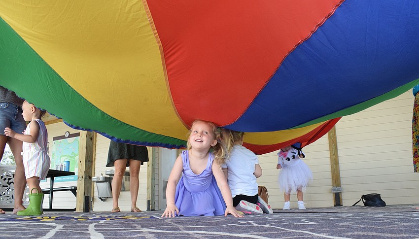 Sarasota's Nora LaDow laughs as the parachute falls on her.