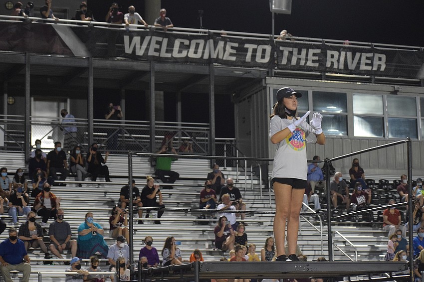 Audience members watch as Allison Guzman, a senior and drum major, leads the band.