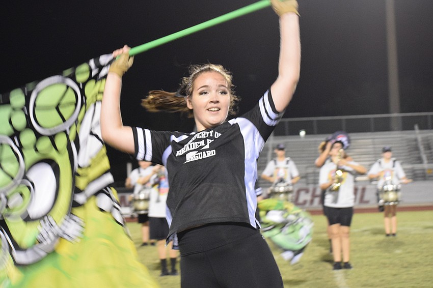 Gianna D'Alessio smiles while performing with the color guard and band.
