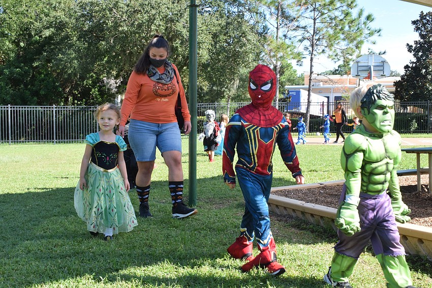 Ava Harris walks alongside her teacher, Valerie Woytysiak, while Captain Harney and Kellen Duggin walk ahead of them in the parade.
