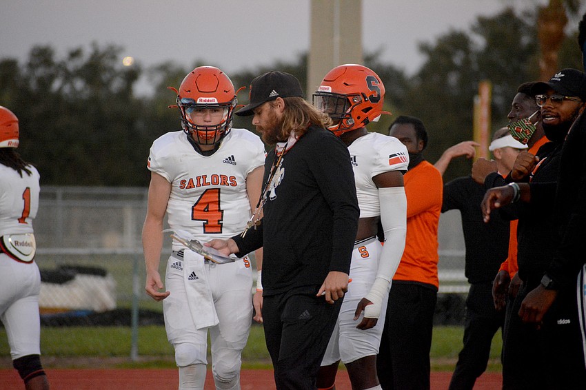Sailors quarterback Lance Trippel chats with Coach Brody Wiseman before the game.
