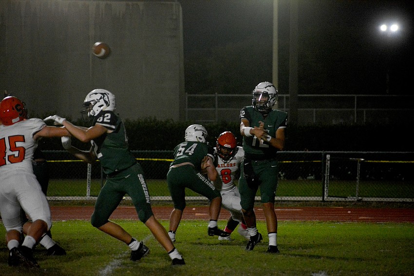 Mustangs quarterback Cameron Madison slings a pass to his left.
