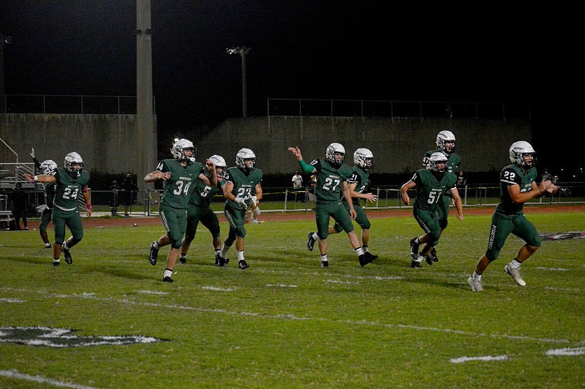 The Mustangs defense celebrates after stopping the Sailors on fourth and one.