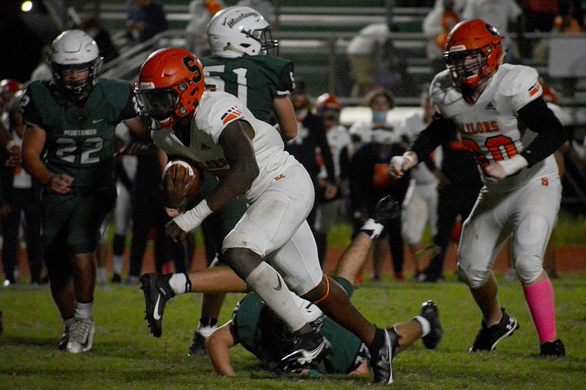 Sarasota running back Jarmel Holloway fights through the middle of the Mustangs defense.