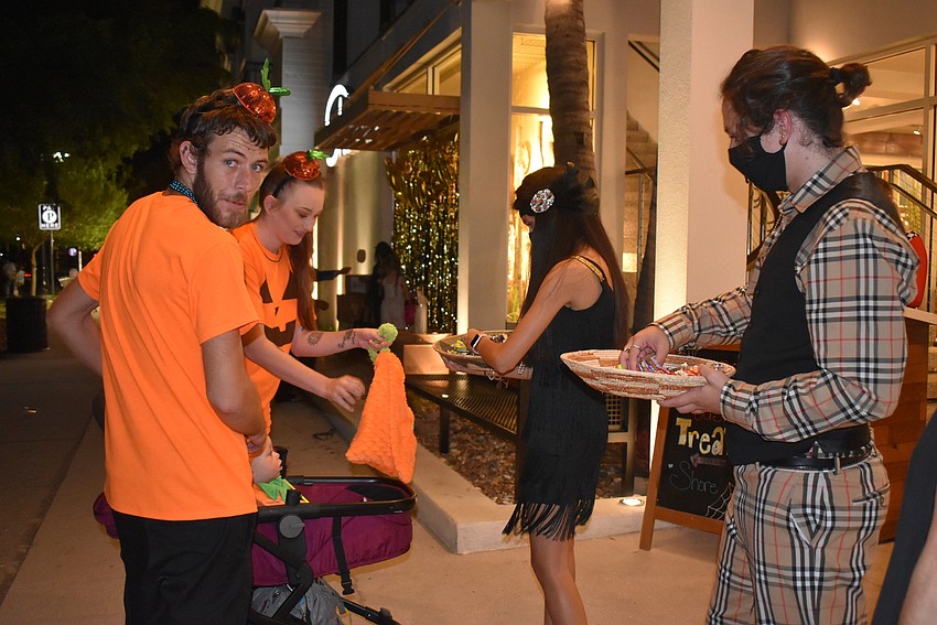 Cody Donnellan pushes daughter Olivia's stroller as Tiffany Kellogg gets candy.