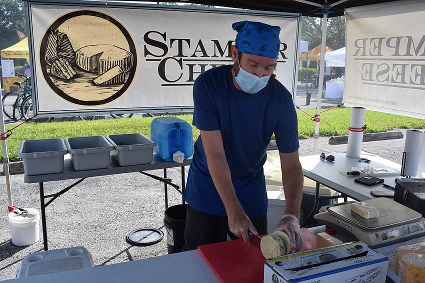 Wisconsin Cheese Curds' Matthew Olson cuts a slice of cheese. He says he is happy to be back in the swing of things.