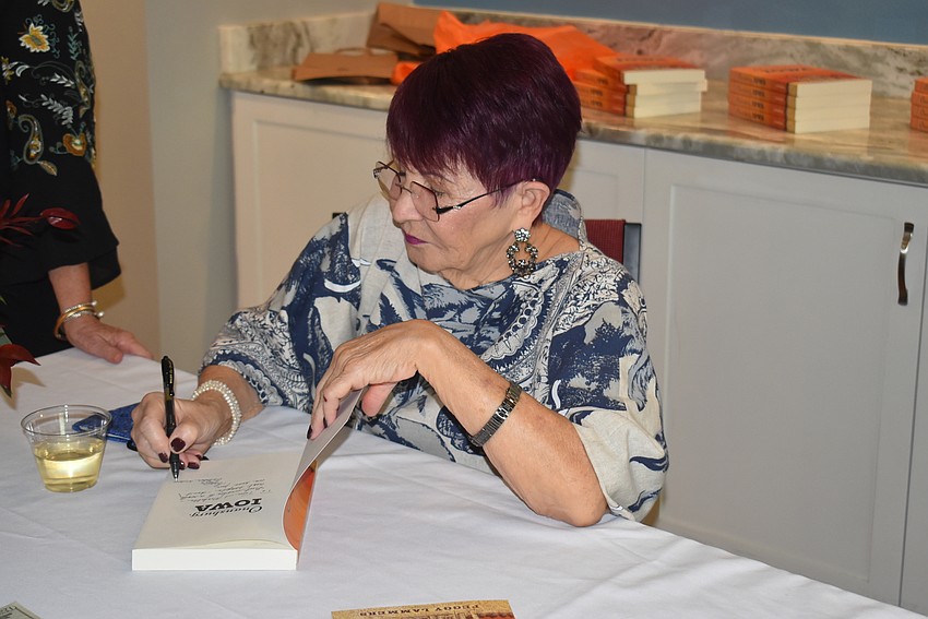 Peggy Lammers signs a book.