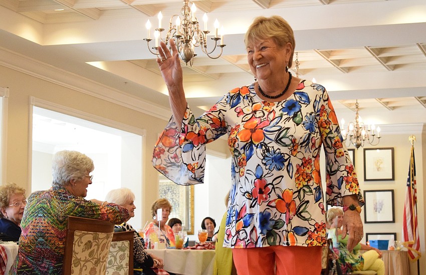 Judy Soutar waves to a group as she goes down the runway for the first time.
