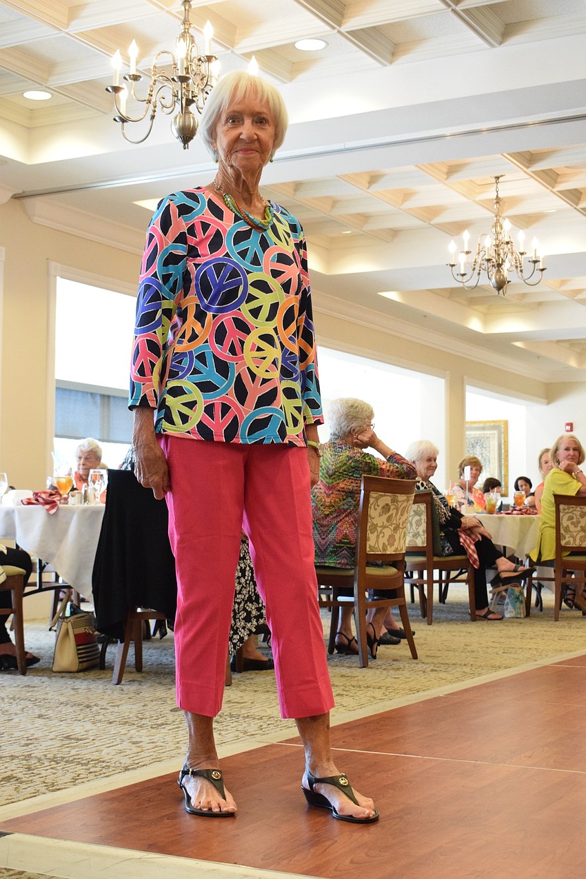 Wilma McCray reminds fashion show viewers of Woodstock with a top covered in peace signs.