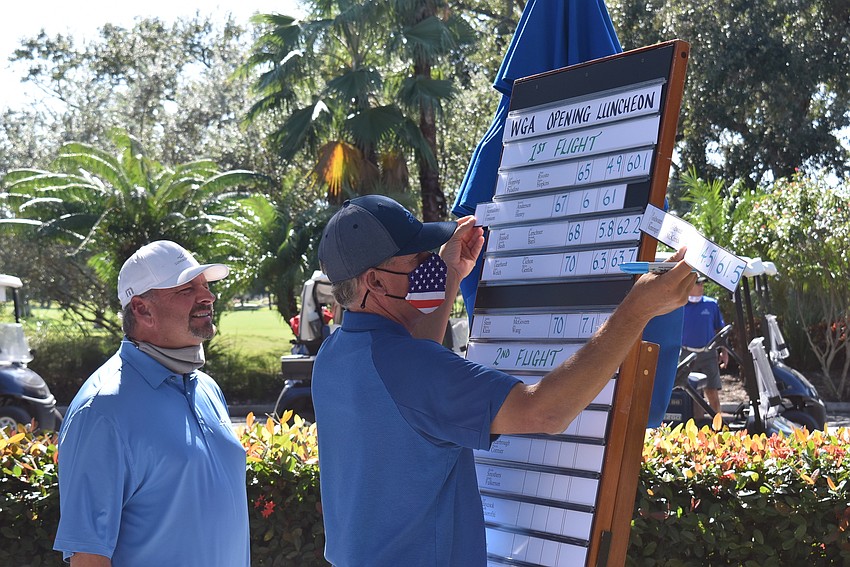 Golf pros Terry O'Hara and Jim Richard tally the day's winners.