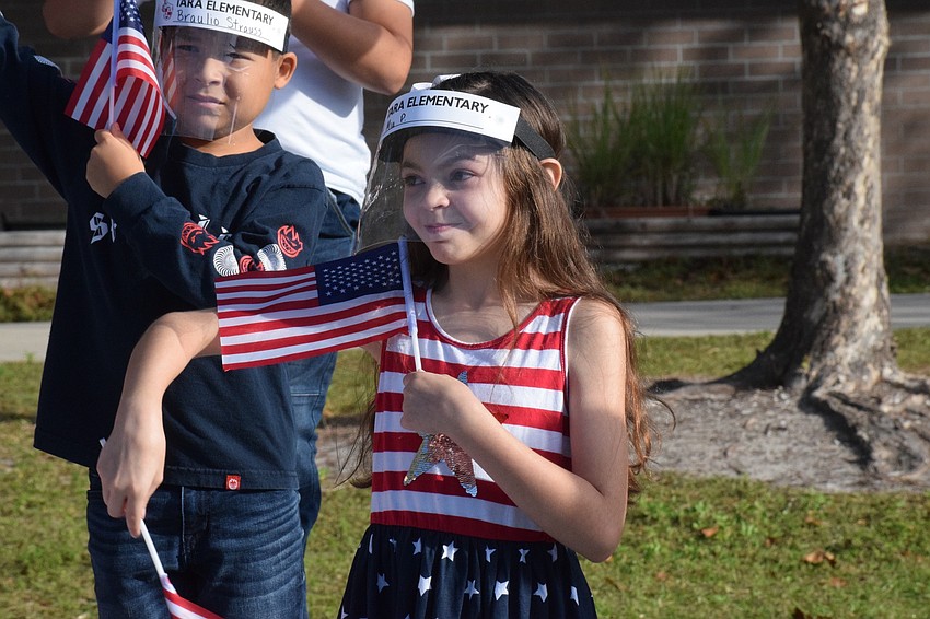 Mia Perez, a fourth grader, waves flags to the music.