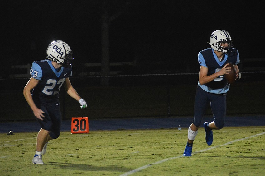 Grady Paxton (23) runs an option play with Patch O'Keefe.