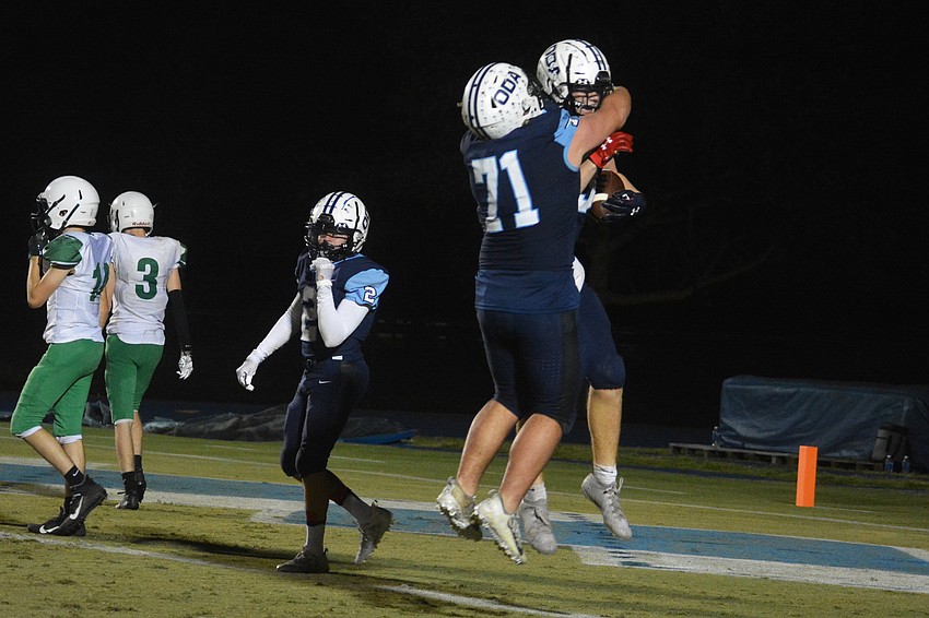 Austin Goins (71) hugs Henry Fioriglio after a Fioriglio touchdown.